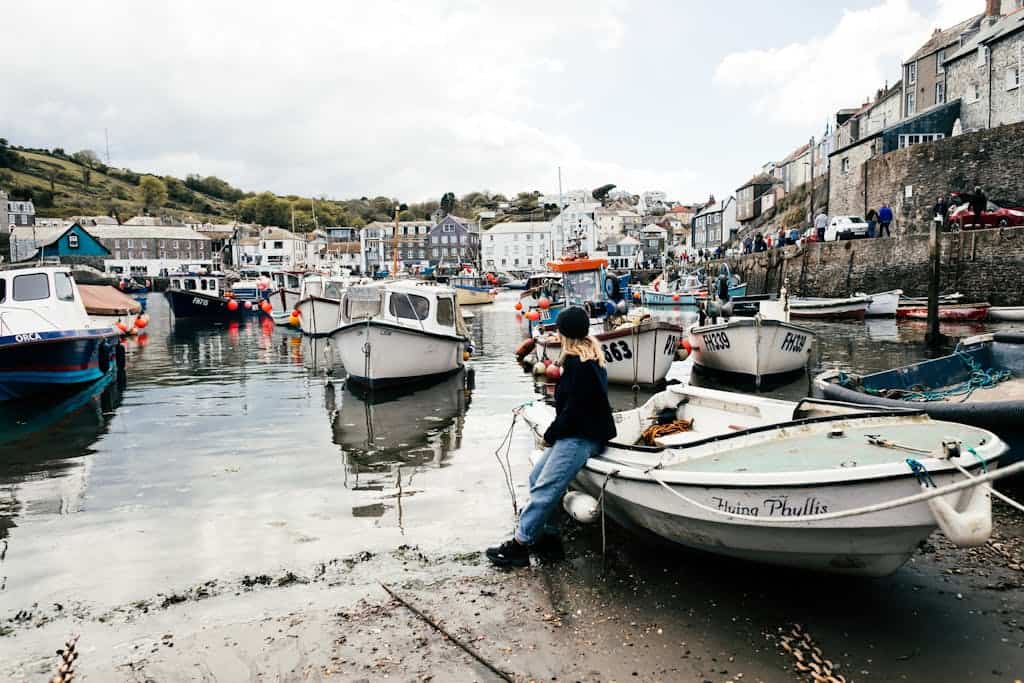 Charming Cornish harbor scene with boats and classic seaside architecture in England, United Kingdom.