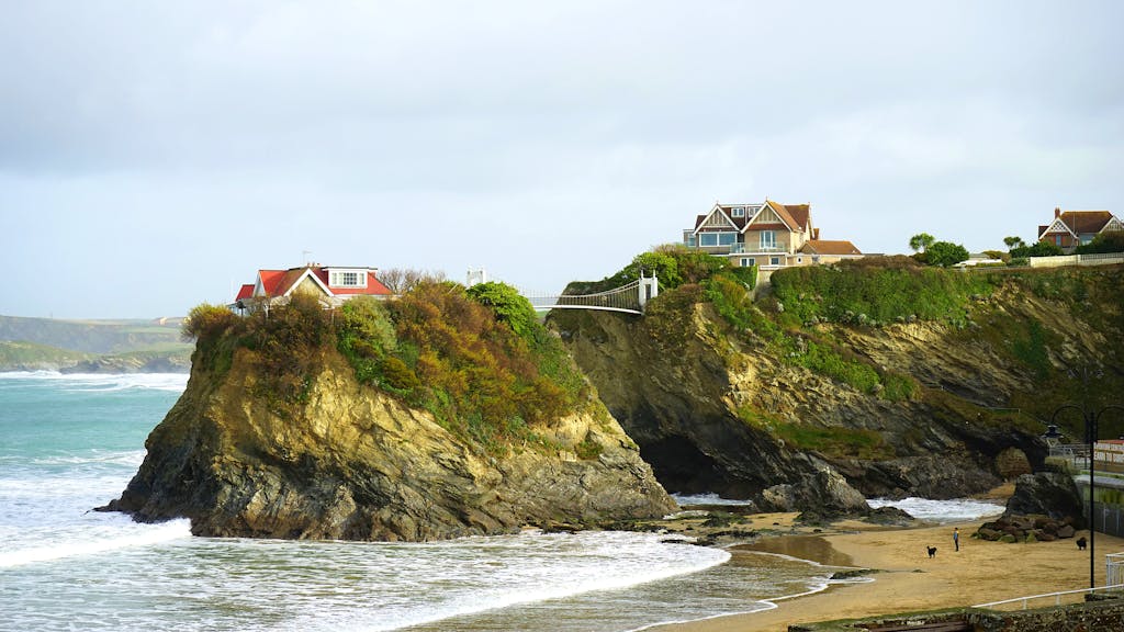 Picturesque coastal view of homes perched on rocky cliffs overlooking the sea.